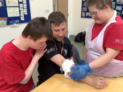 A man gets bandaged by two young people